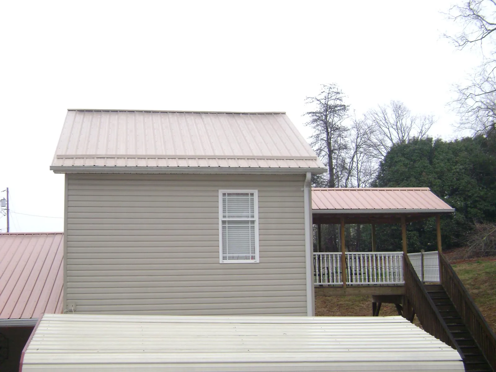 Tan metal roofs on a two story addition and attached porch, from a Roof Replacement job in Sunnyvale